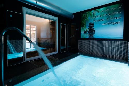 a swimming pool with a tv in a bathroom at Villa Nonna Cicci Boutique Hotel - SPA in Cisterna dʼAsti