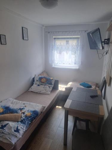 een kleine kamer met 2 bedden en een tafel bij Mieszkanie Nowa Łomnica in Duszniki Zdrój