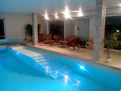 a swimming pool with a table and chairs next to it at Lumineux F3 avec piscine et exterieur in Geudertheim