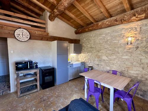 une cuisine avec une table en bois et des chaises violettes dans l'établissement Hotel Majestic, à Nîmes