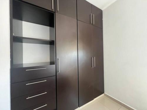 a closet with dark brown cabinets in a room at Departamento Torres Mina Residencial in Villahermosa