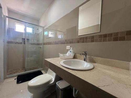 a bathroom with a sink and a toilet and a mirror at Departamento Torres Mina Residencial in Villahermosa