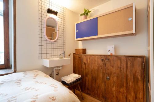 małą sypialnię z łóżkiem i umywalką w obiekcie SoHome Le Chable w mieście Le Châble