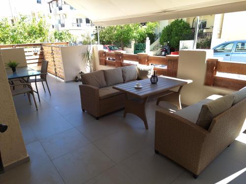 um pátio com sofás, uma mesa e cadeiras em modern apt near Heraklion city & airport em Néa Alikarnassós