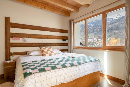 Un dormitorio con una cama y una ventana grande. en SoHome Le Chable - Self Check-in, en Le Châble
