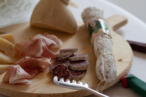 a wooden cutting board with meat and sausage on it at Moliké country house in Giulianova