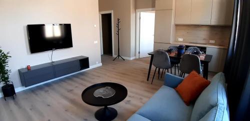 uma sala de estar com um sofá azul e uma mesa em Giertmaņa apartamenti em Liepāja