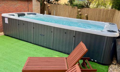 a chair and a hot tub in a backyard at Stratford-upon-Avon 4BR Family Mansion on 1 acre with Pool, Gym & BBQ! in Henley in Arden