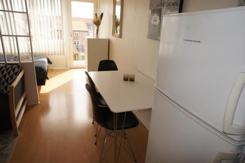 uma cozinha com um frigorífico branco e uma mesa em (id038) Gormsgade 96 3 sal dør 13 em Esbjerg