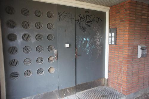 una porta di metallo con graffiti sul lato di un edificio di (id038) Gormsgade 96 3 sal dør 13 a Esbjerg