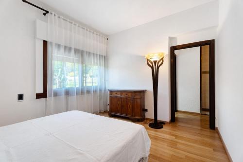 a bedroom with a bed and a lamp and a window at Villa azalea in Induno Olona