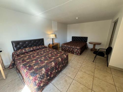 a hotel room with two beds and a table at Airport Motel in Pasco