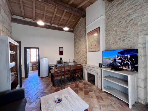 sala de estar con TV y chimenea en Hotel Majestic en Nimes