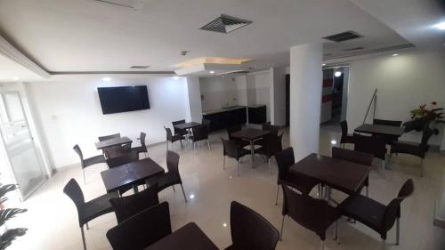 a room with tables and chairs and a flat screen tv at HOTEL MILLA SUITES MERIDA in Mérida
