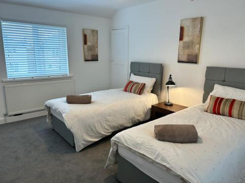 Frodingham的住宿－Montrose House 3 bedroom home with Parking，一间卧室设有两张床和窗户。
