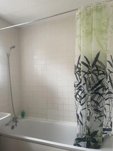 y baño con bañera y cortina de ducha. en Immaculate 3-Bed House in Luton, en Luton
