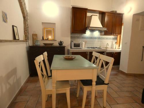 a kitchen with a table and chairs and a microwave at SCAPPO IN UMBRIA, nel vicolo in Amelia