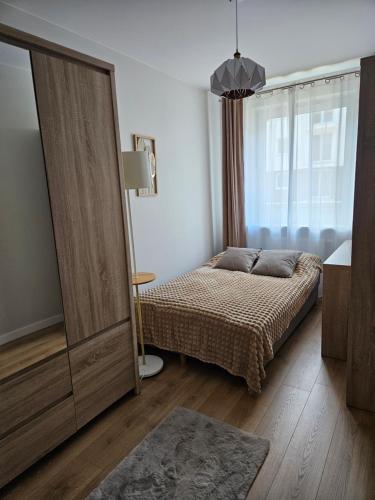 1 dormitorio con 1 cama y puerta corredera grande en Urban Jungle Apartament Brown, en Białystok