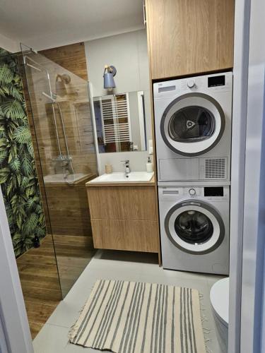 a bathroom with a washing machine and a sink at Urban Jungle Apartament Brown in Białystok