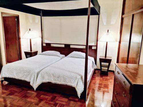 een slaapkamer met een hemelbed en 2 lampen bij Studio with city view and wifi at Funchal 5 km away from the beach in Funchal