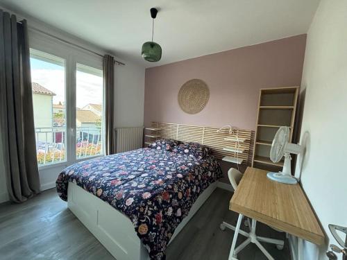 a bedroom with a bed and a desk and a window at Appart Lumineux Chaleureux in Montpellier