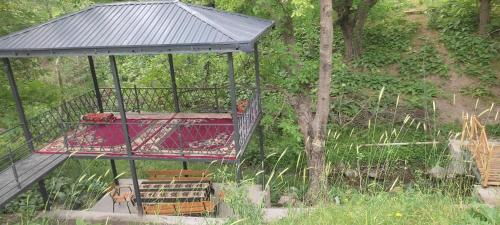 a gazebo with a table and chairs on it at Firdavs guesthouse in nuratau mountain in Yukary-Ukhum