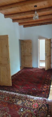 Pokój z drewnianymi szafkami i dużym dywanem w obiekcie Firdavs guesthouse in nuratau mountain w mieście Yukary-Ukhum