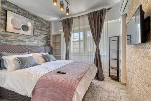 a bedroom with a large bed and a brick wall at RDI Elegance Apartment Downtown in Bucharest