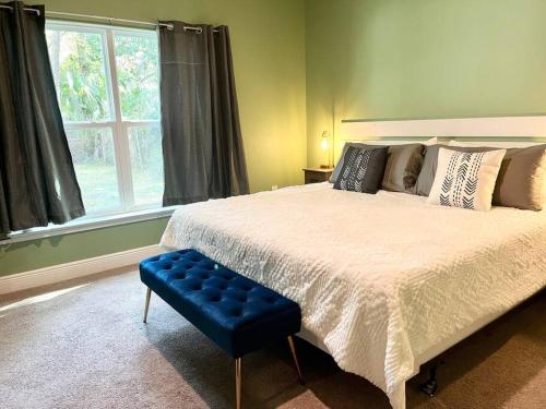 1 dormitorio con 1 cama grande y 1 taburete azul en Sweet Stay with fully fenced yard en Sanford