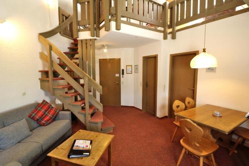 a living room with a couch and a table and a staircase at Apartment 16 - Ferienresidenz Roseneck, Galeriewohnung, mit Schwimmbad in Todtnauberg bei Feldberg in Todtnauberg