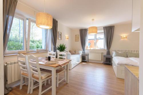 a kitchen and dining room with a table and a bedroom at Słone 103 in Kudowa-Zdrój