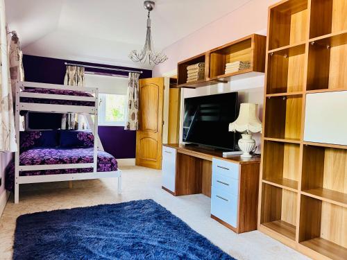 a bedroom with a bunk bed and a tv at Stratford-upon-Avon 4BR Family Mansion on 1 acre with Pool, Gym & BBQ! in Henley in Arden