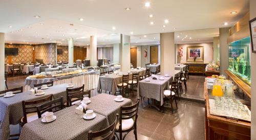 a restaurant with tables and chairs in a room at Hotel Impala in Buenos Aires