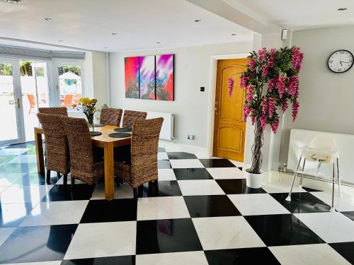 a dining room with a table and chairs and a vase with flowers at Stratford-upon-Avon 4BR Family Mansion on 1 acre with Pool, Gym & BBQ! in Henley in Arden