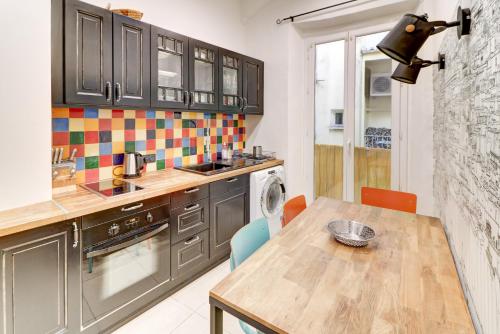 La cuisine est équipée d'une table, d'un évier et d'un lave-vaisselle. dans l'établissement Lovely Cosy Flat in Nice old town, à Nice