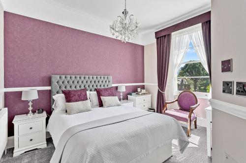 Dormitorio púrpura con cama y lámpara de araña en The Berburry en Torquay