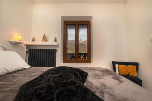 um quarto com uma cama, uma janela e uma cadeira em Chalet les Myrtilles em Venthon