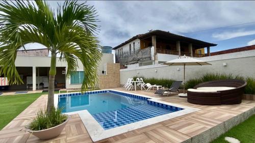 a backyard with a swimming pool and a house at Casalagorios - ilha de Itaparica - Berlinque in Vera Cruz de Itaparica