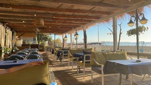 una fila de mesas y sillas en un restaurante de playa en Hotel Benilva, en Durrës
