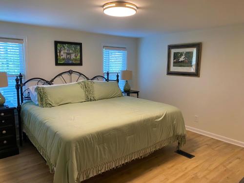 a bedroom with a bed and two windows at Whiskey Woods in Frankfort