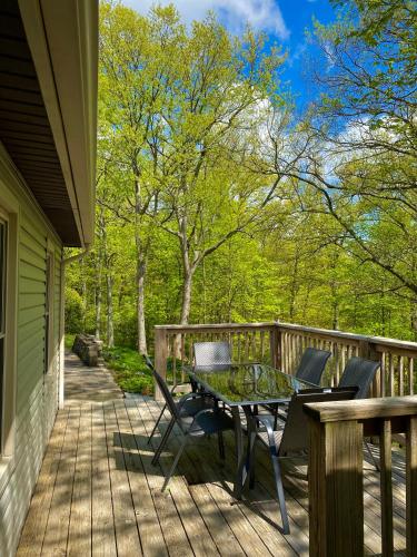 a patio with a table and chairs on a deck at Whiskey Woods in Frankfort
