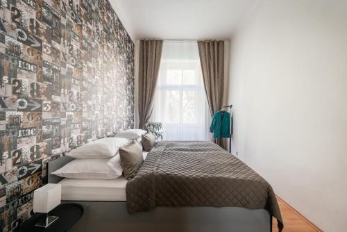 a bedroom with a bed and a wall covered in photographs at Prague - Karlin Apartments in Prague