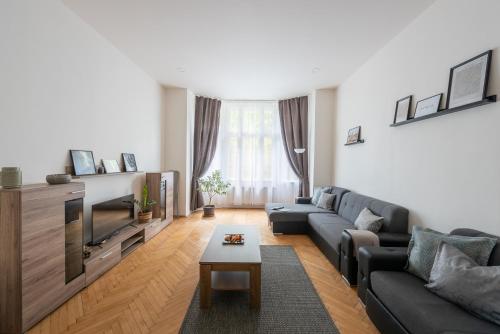a living room with a couch and a tv at Prague - Karlin Apartments in Prague