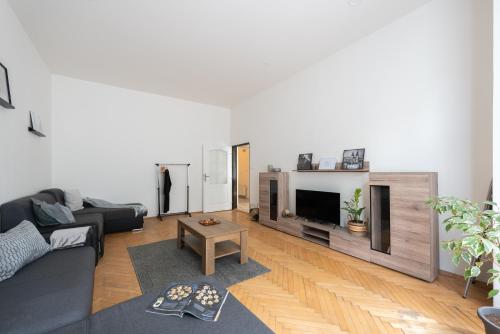 a living room with a black couch and a tv at Prague - Karlin Apartments in Prague