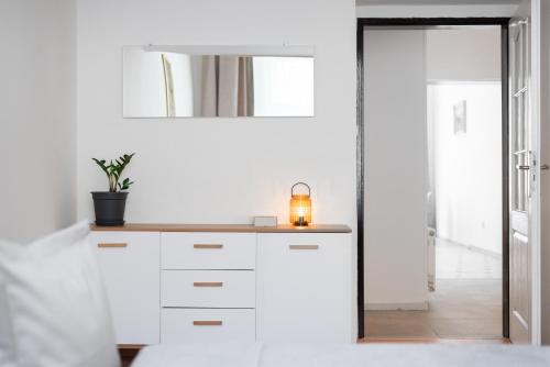 a white kitchen with a sink and a mirror at Prague - Karlin Apartments in Prague