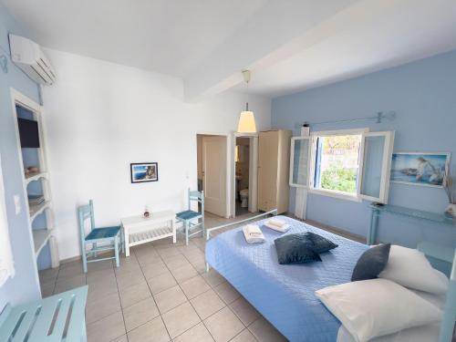 a bedroom with a blue bed in a room at Pension Barbara in Katapola