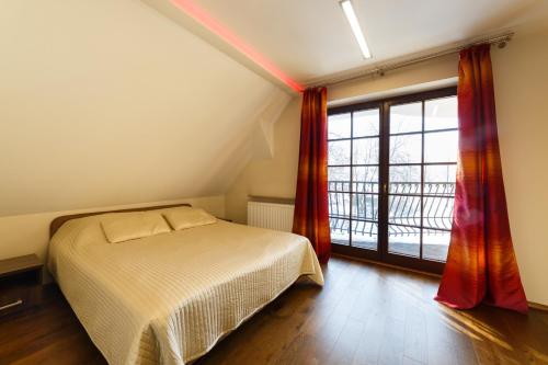 a bedroom with a bed and a large window at Apartamenty-Plaza Zakopane in Zakopane