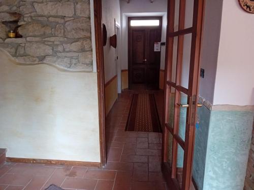 a hallway with a door and a stone wall at Su Mulinu 