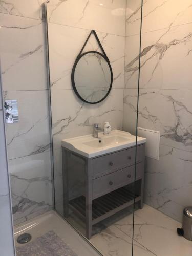 une salle de bain avec un lavabo et une douche avec un miroir dans l'établissement Sainte Cécile 2- Studio élégant, idéalement situé, à Vichy