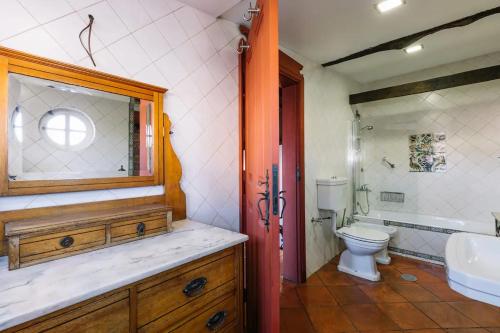 uma casa de banho com um lavatório e um WC em Casa da Pedra Cavalgada em Braga